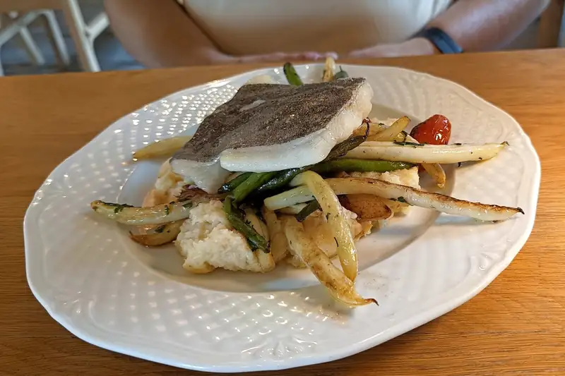 Halibut z warzywami na białym talerzu